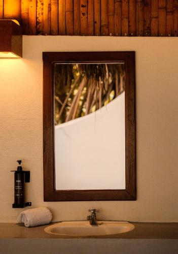 a mirror above a sink in a bathroom at Hotel Playa Bonita Tayrona in Buritaca