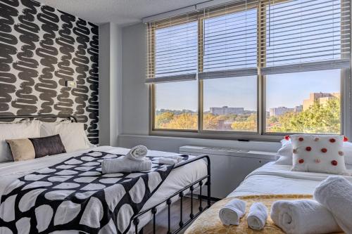 Un dormitorio con dos camas y una gran ventana. en Stylish Apartment 5 min to DC with free Gym and Parking, en Arlington