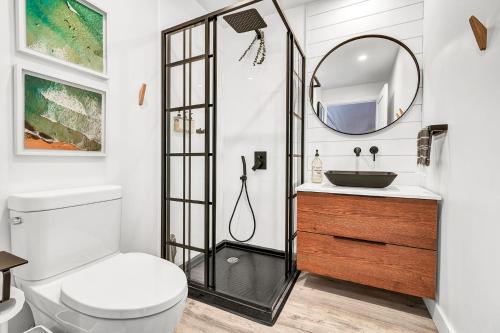 a bathroom with a toilet and a sink and a mirror at Nalu Retreat Glamping Domes in Porters Lake