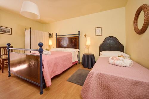 a bedroom with two beds with pink sheets at Cozy Tuscany Apartment in SUVERETO by Countryside & Sea in Suvereto
