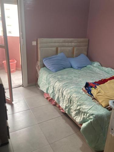 a bed with blue pillows on it in a room at Blue Wave Apartments Anza in Agadir