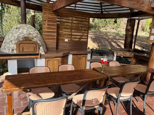 d'une terrasse avec une table, des chaises et un four. dans l'établissement Hermosa casa de campo en Lamay -Calca, à Cusco