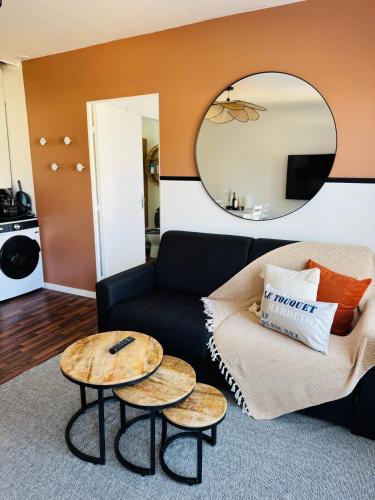 a living room with a couch and two tables at Stella - 1km plage - centre ville in Stella-Plage