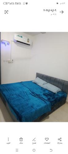 Un dormitorio con una cama con un edredón azul. en صلاله, en Salalah