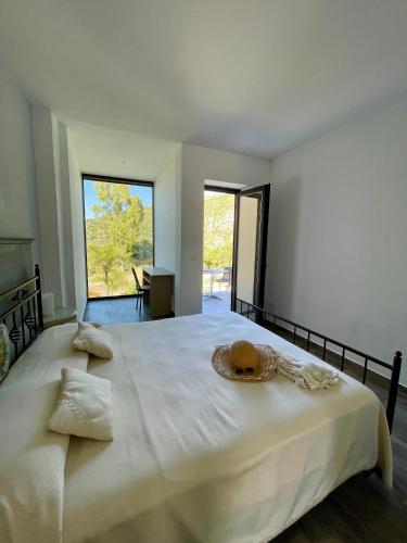 a large white bed with a hat on top of it at B&b Le paradis in Castel di Tusa