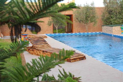 a swimming pool with lounge chairs next to a house at auberge Brava Tifnit 