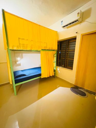a small room with a bunk bed with a window at Yes Hostel Varkala - Black Beach Road in Varkala