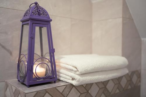 a purple lantern sitting on a table with towels at Pokoje Gościnne IRGA Apartamenty in Starogard Gdański