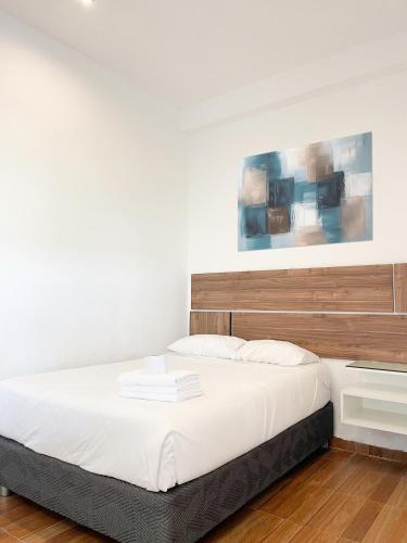 a bedroom with a large bed with a wooden headboard at Mystic Paracas Hotel & Glampings in Paracas