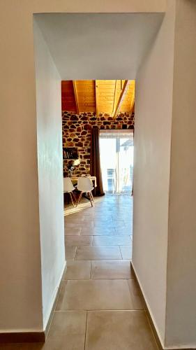 an open hallway with a stone wall and a room with a tile floor at Cassiopea Guest House Evia Greece in Nerotriviá
