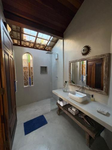 a bathroom with a sink and a mirror at Gizele Sander Arte & Hospedagem in Ilhabela