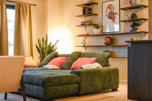 a living room with a green couch with pink pillows at Signature View Apartment in Accra