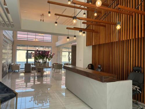 a woman sitting at a counter in a lobby at Signature View Apartment in Accra