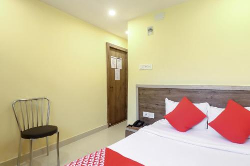 a bedroom with a bed with red pillows and a chair at Hotel O 67309 Hotel Tuk Tuk Palace in Rānchī