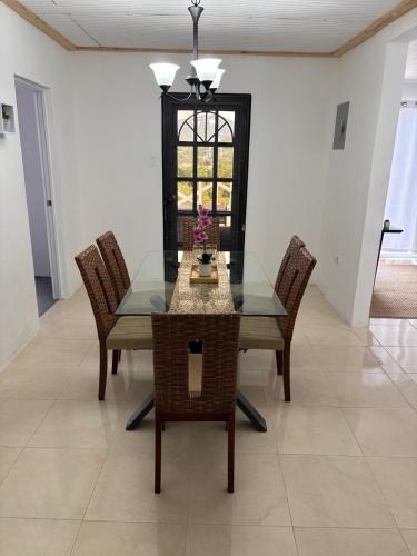 a dining room with a glass table and chairs at Hacienda Bella Vista in Limones