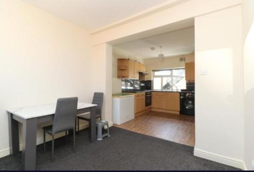 a kitchen and dining room with a table and chairs at Beach Next Door Flat in Margate