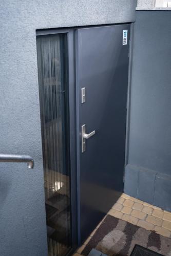 a blue door in a building with a window at Pokoje Gościnne IRGA Apartamenty in Starogard Gdański