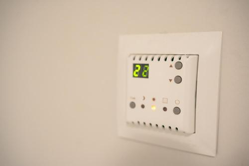 an electronic clock on a white wall at Pokoje Gościnne IRGA Apartamenty in Starogard Gdański