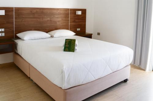 a large white bed with a book on it at Mystic Paracas Hotel & Glampings in Paracas
