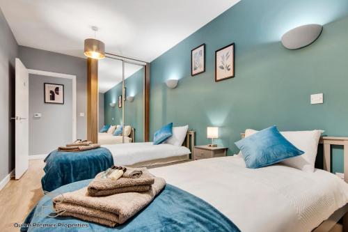 Dos camas en una habitación con paredes azules. en Deluxe Croydon Apartment - NHS & Professionals, en Londres
