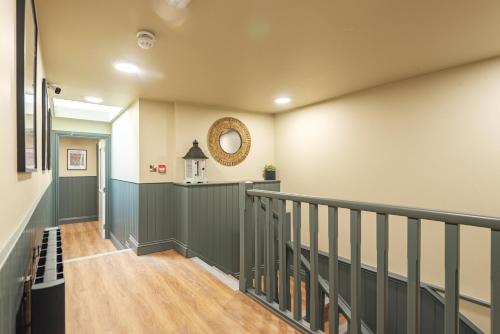 a hallway with green and white walls and a staircase at Central Whitchurch - Lowcross House Guest Bedroom 4 in Whitchurch