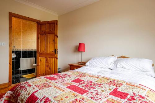 a bedroom with a bed with a quilt on it at Spacious Home by Lough Rynn Castle Wedding Venue in Mohill