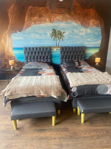 a bedroom with two beds and a painting of the ocean at A6 Apartment Wadgassen in Wadgassen