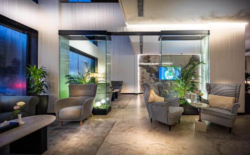 a lobby with chairs and plants in a building at Tuvana Hotel in Jeddah