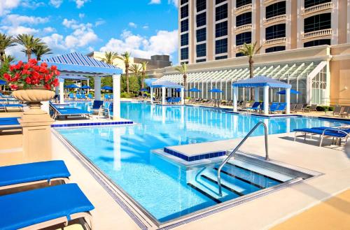 a large swimming pool with blue chairs and a building at Beau Rivage Resort & Casino in Biloxi