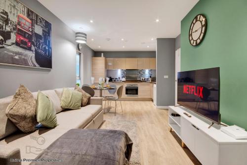 Una sala de estar con un sofá y un reloj en la pared. en Deluxe Croydon Apartment - NHS & Professionals, en Londres