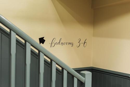 a sign on a wall next to a staircase at Central Whitchurch - Lowcross House Guest Bedroom 5 in Whitchurch