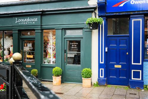 a store front with blue doors and potted plants in front at Central Whitchurch - Lowcross House Guest Bedroom 5 in Whitchurch