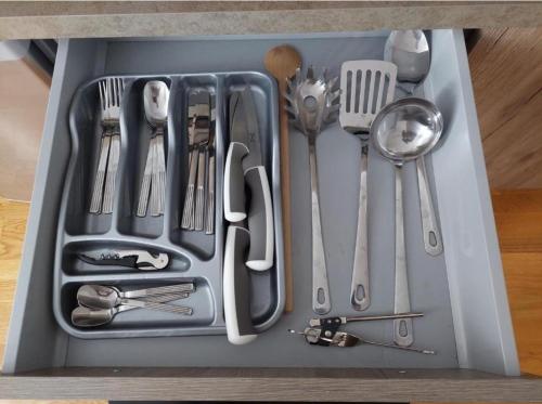 a tray filled with utensils sitting on a table at Apartment Aleksandar AS in Brzeće