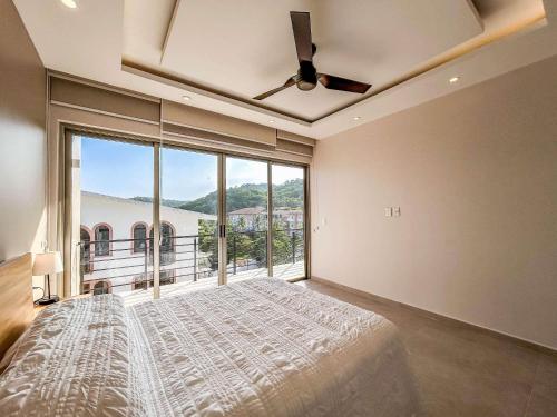 ein großes Schlafzimmer mit einem Bett und einem großen Fenster in der Unterkunft Costta C305 - Santa Cruz in Santa Cruz Huatulco