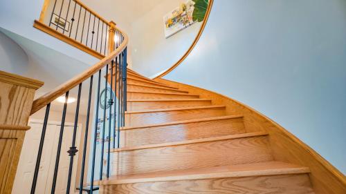 a wooden staircase with wooden treads and a metal railing at Diana House in Charlottetown