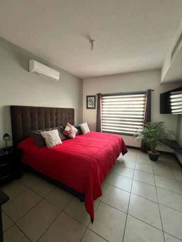 a bedroom with a large bed with a red blanket at Residence in Chihuahua in Chihuahua