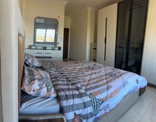 a bedroom with a large bed with a window and a window at شقة لك بالكامل in Ajloun