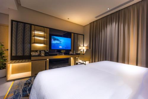 a hotel room with a bed and a television at Tuvana Hotel in Jeddah