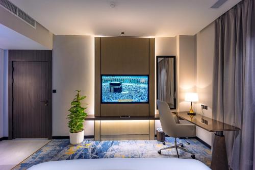a hotel room with a desk and a television at Tuvana Hotel in Jeddah