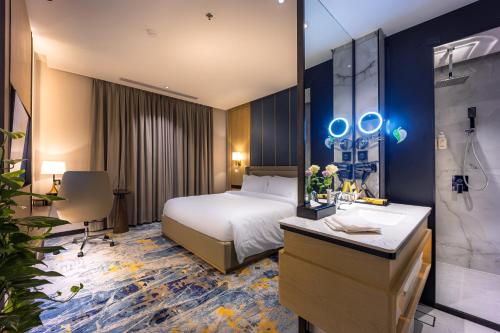 a hotel room with a bed and a bathroom at Tuvana Hotel in Jeddah