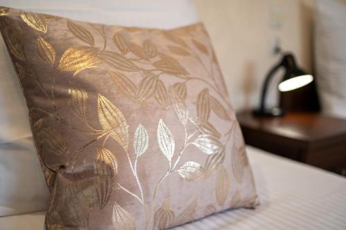 a pillow sitting on a bed next to a lamp at Pokoje Gościnne IRGA Apartamenty in Starogard Gdański