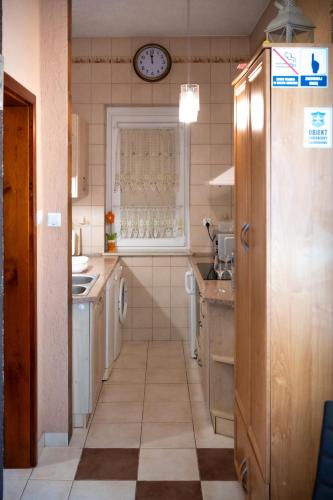 a kitchen with a sink and a clock on the wall at Pokoje Gościnne IRGA Apartamenty in Starogard Gdański