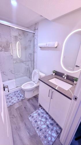 a bathroom with a toilet and a sink and a shower at Modern Comfort Stay Near Airport in Edmonton
