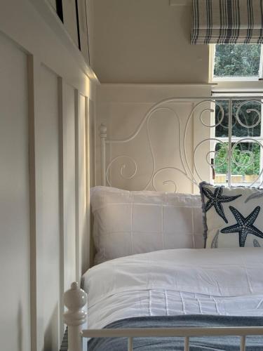 una camera da letto con un letto bianco e una finestra di Emma's Cottage a Glenarm