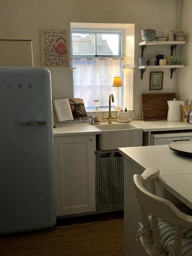 una cucina con lavello e frigorifero di Emma's Cottage a Glenarm