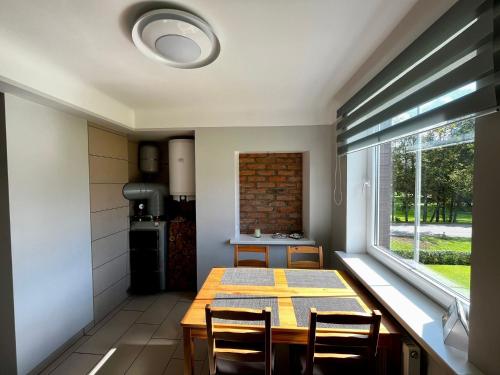 a kitchen and dining room with a table and a window at Ergli Holiday Apartments in Ērgļi