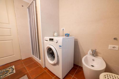 a bathroom with a washing machine and a toilet at Casa Fortuna - con solarium panoramico a Castellabate in Castellabate