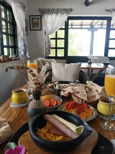 einen Tisch mit Teller mit Lebensmitteln und Gläsern Orangensaft in der Unterkunft Hotel Estancia Villa Blanca in Villa de Leyva