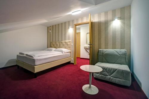 a bedroom with a bed and a chair and a table at Hotel Skradinski Buk in Skradin