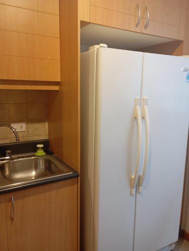 a white refrigerator in a kitchen with a sink at Departamento de Lujo sector Bosmediano in Quito